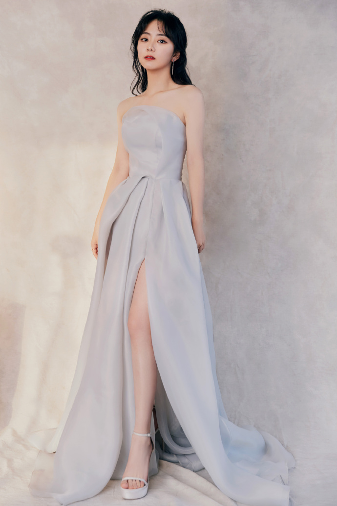 12月22日，谭松韵水雾蓝抹胸裙现身某活动，优雅又灵动，大秀锁骨腰线。