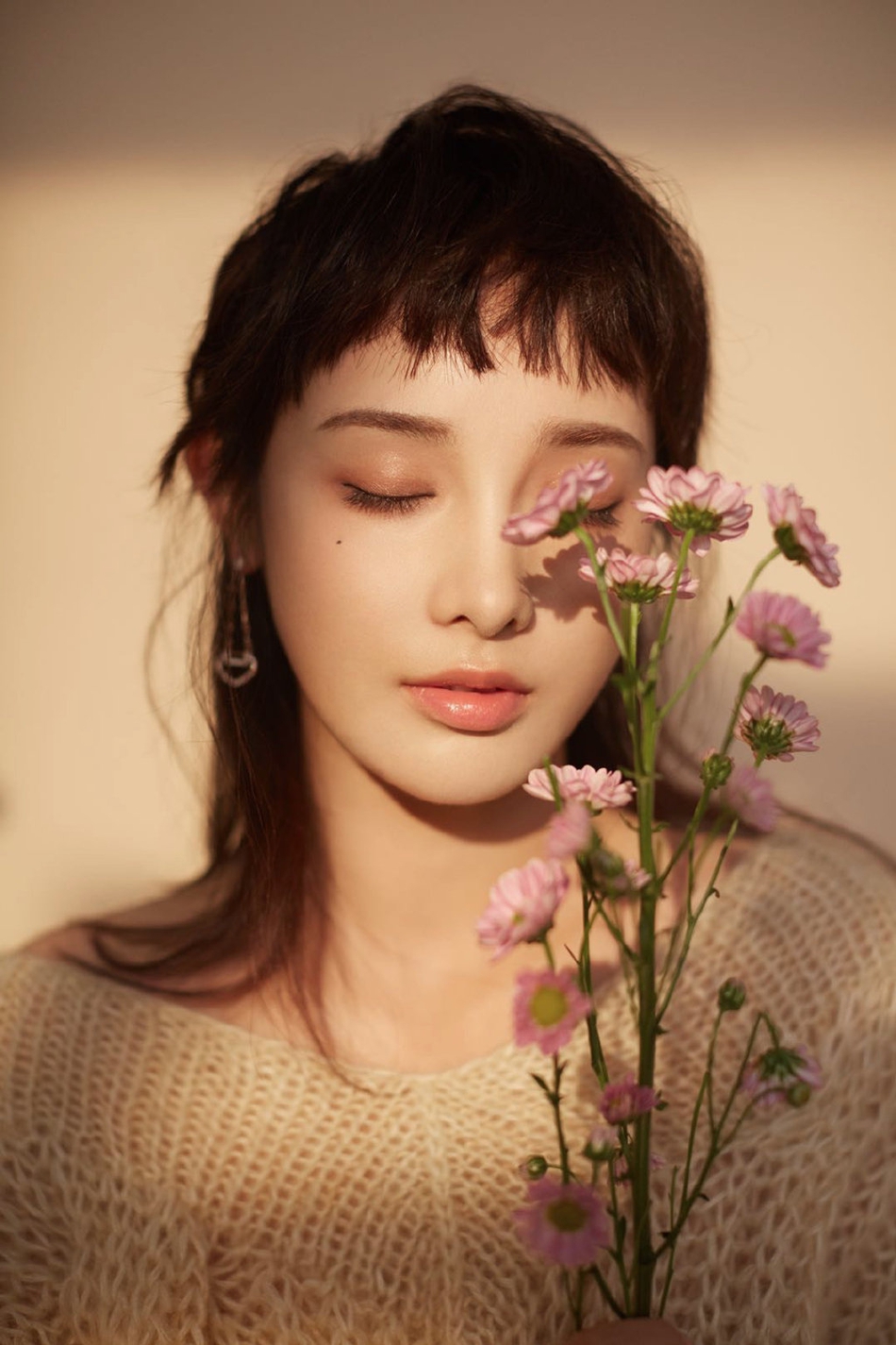 彭小苒微闭双眼，在鲜花的衬托下格外美丽。