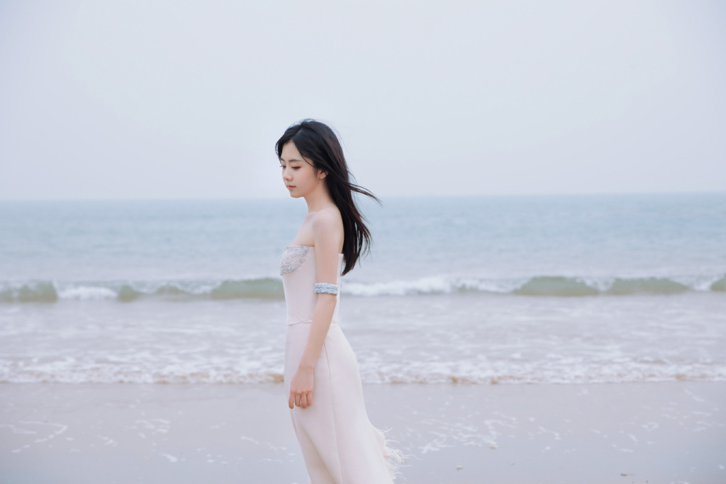 1月15日，谭松韵工作室晒出一组海边绝美大片，当天，谭松韵身穿白色低胸长裙在海边拍摄写真，气质优雅，十分迷人。