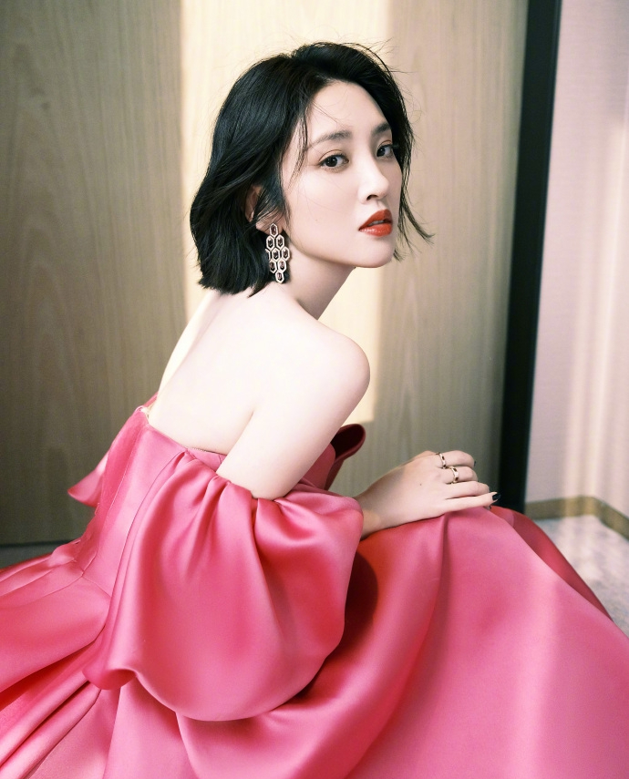 3月20日，唐艺昕晒出一组美照。照片中她穿玫红色V领抹胸裙，酥胸隐现，半露美背肩颈线优越，短发微微凌乱，性感撩人。