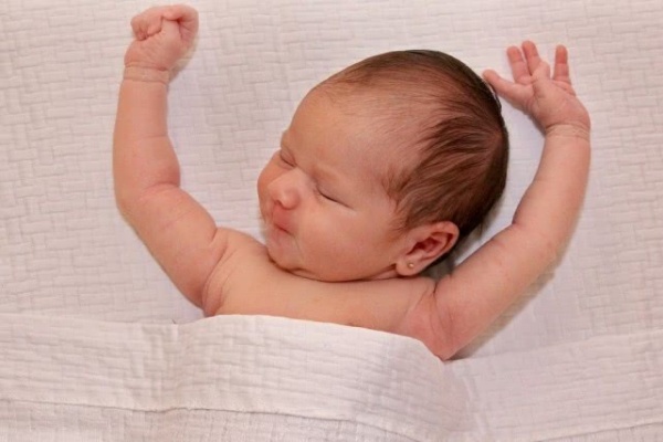 睡觉时,孩子举起双手,大脑发育良好